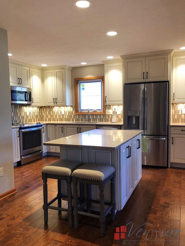 Kitchen remodel, Antique white raised panel cabinets with chocolate glazing, quartz countertops, glass tile backsplash, stainless steel appliances, hardwood flooring, pull down sink faucet, oiled rubbed bronze hardware, double equal under-mount kitchen sink